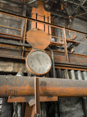 Old rusty pipelines covered with layers of dust and grime stand alongside industrial clocks