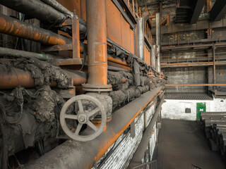 Close-up of rusty shut-off valves and pipelines showing signs of long-term use and natural aging.