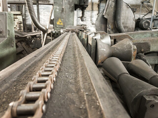 Close-up of a heavy chain used to secure graphite electrodes during nipple cutting.