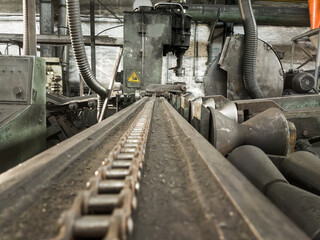 Close-up of a heavy chain used to secure graphite electrodes during nipple cutting.