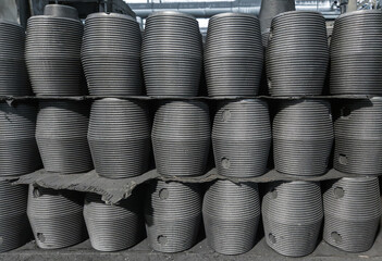 A neat stack of graphite nipples contrasts with the grimy workshop environment