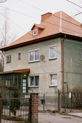 old brown building with a balcony. The building is surrounded by a fence. walking in the old town, traveling to tourist places.