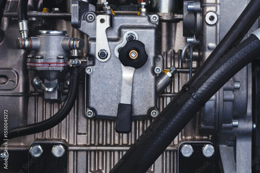 Poster close up of a car engine with a black hose attached to it. the hose is connected to a black valve