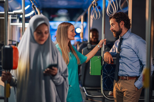 Nurse talking to businessman on public transport bus
