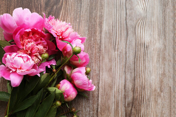 Floral frame with pink peonies on wooden background