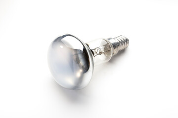 A reflective light bulb on a white background. The bulb has a shiny, metallic surface and a...