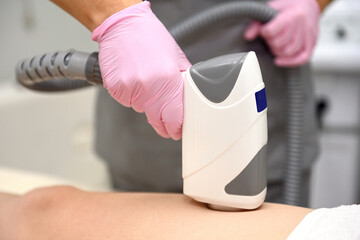 Diode laser hair removal, Cosmetologist removes hair on women's legs, Epilation for smooth skin,...