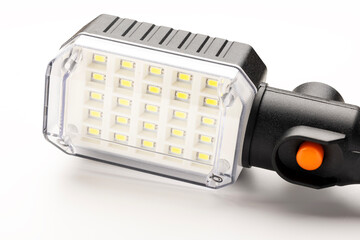 A modern LED lamp with a rectangular light panel and a black handle. The lamp is positioned on a...