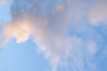 Soft clouds float in a blue sky, creating a serene and abstract background. The light colors blend...