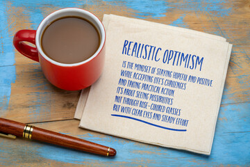 Realistic optimism - mindset that combines a hopeful outlook with an honest assessment of reality. Note on a napkin.