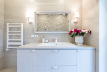 Bright Elegant Modern Luxury Scandinavian Bathroom Interior Design of Bathroom. LED Lights. WC, White Sink. Heater. Flowers on the Desk