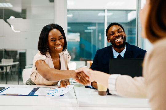 Business partners shaking hands after successful meeting in modern office