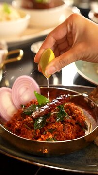 Lemon Getting Squeezed onto a Plate of Chicken Keema Pav - Classic Indian Chicken Keema Pav