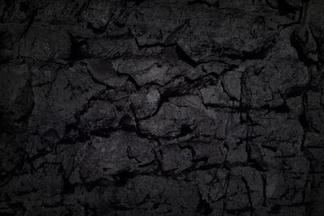 Texture of black tree bark, trunk, coal background. Dark wallpaper with rough cracked texture. Wooden wall concept, smoking wood plank backdrop. Abstract surface mockup. Top view, close up, copy space
