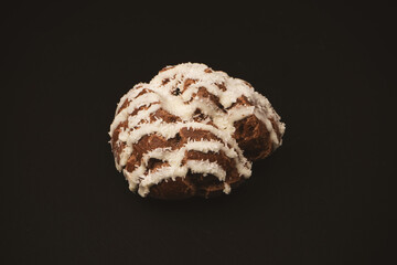 Profiteroles with coconut cream on a black background.