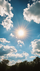 The sun shines through the clouds, creating a bright blue sky with white clouds. A lens flare is visible in front of it. Trees are visible in the distance.