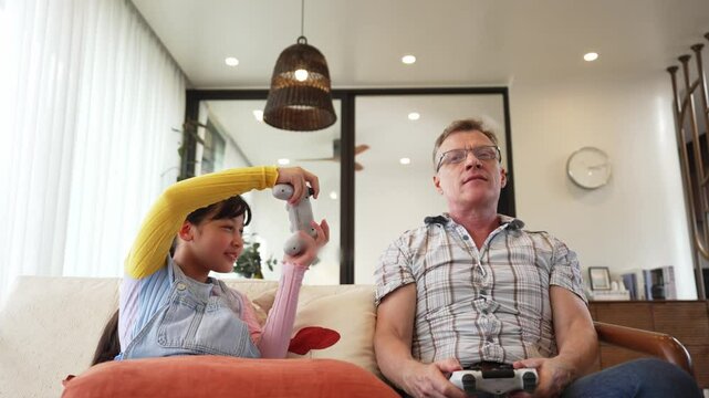 Granddaughter teaching grandfather play console game, entertainment hobby. Old senior use technology communicate with new generation kid cross generation gap strengthen family bond. Divergence.