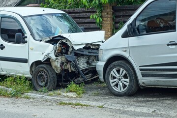 broken and deformed front part of passenger white industrial modern car with wheel and windshield...
