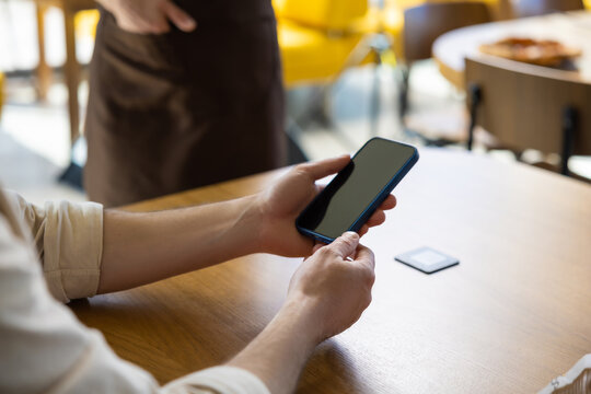 Customer using phone to scan menu at restaurant