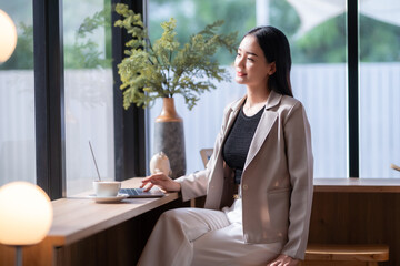 Asian freelance people business female talking making using casual working with laptop computer and coffee at home in the living room indoors artificial rose bouquet of red and pink roses rose vase