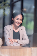 Asian freelance people business female talking making using casual working with laptop computer and coffee at home in the living room indoors artificial rose bouquet of red and pink roses rose vase