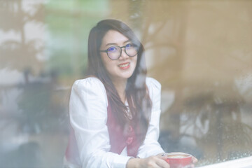 Close-up beautiful happy Smiling of hands Holding cup mug of Hot coffee latte wits business female in coffee shop like the background, communication concept
