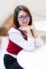 Portrait of beautiful happy Smiling asian woman relaxing sitting in cafe interior in coffee shop background