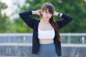 Portrait of beautiful asian Young woman in Black robe sportswear working out outside. training on public equipment in outdoor at park. concept Exercise Healthy lifestyle.