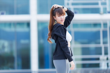 Portrait of beautiful asian Young woman in Black robe sportswear working out outside. training on public equipment in outdoor at park. concept Exercise Healthy lifestyle.