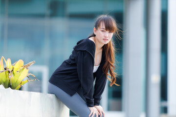 Portrait of beautiful asian Young woman in Black robe sportswear working out outside. training on public equipment in outdoor at park. concept Exercise Healthy lifestyle.