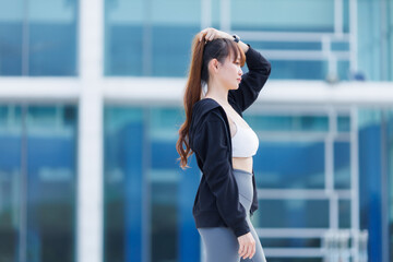 Portrait of beautiful asian Young woman in Black robe sportswear working out outside. training on public equipment in outdoor at park. concept Exercise Healthy lifestyle.