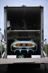 Race Car Loaded in Transport Trailer – Rear View of Performance Vehicle in Motorsport Hauler