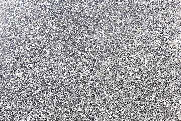 Granite terrazzo floor surface. Detailed texture of speckled gray black stone chips. Polished rough construction material background. Durable flooring tile pattern for architecture and design use.