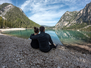 Couple looking at beautiful lake Braies and mountains in Italy