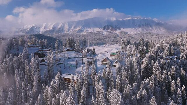 Drone view: luxury hotels glowing in deep snow valleys of Gulmarg.