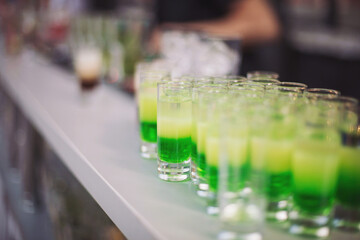 Green elixirs await on the marble bar, a cascade of spirits ready for the night, beckoning...