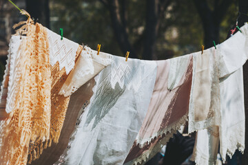 Vintage linens drying in the afternoon sunlight, delicate fabrics swaying gently on a clothesline,...