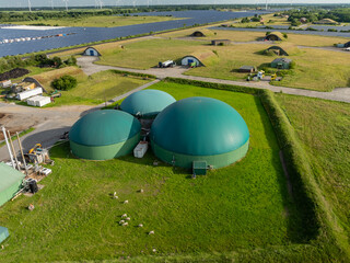 Aerial view of a renewable energy site with biogas domes, sheep grazing, solar field and repurposed...