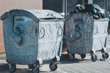 Industrial giants slumber silently on a city street, metal skins reflecting the midday sun while...