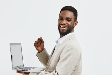 Smiling man of African descent with short curly hair wearing beige blazer and white shirt holding a...