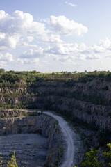 Open-Pit Quarry with Rock Layers and Green Forest Background
