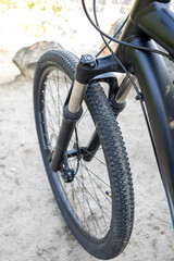 Close-up of front wheel and suspension fork of mountain bike