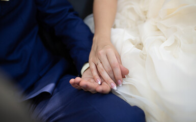 Bride and Groom Holding Hands in Wedding Attire