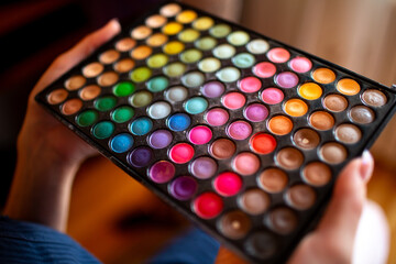 Vibrant eyeshadow palette in female hands
