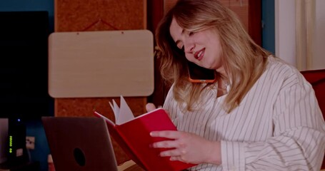 Happy young woman efficiently manages her work from home, using smart devices for communication. She's productive, smiling and engaged in her remote business tasks, showcasing modern digital lifestyle