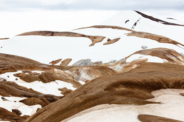 Icelandic highland landscape at Kerlingarfjöll with orange soil, hot springs and snow