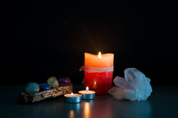 Ritual espiritual con velas encendidas, cristales y piedras energéticas sobre fondo oscuro