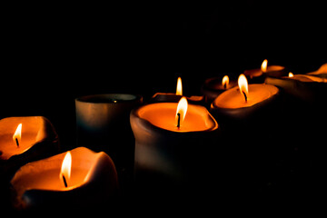 Velas encendidas con llama cálida en ambiente oscuro y relajante