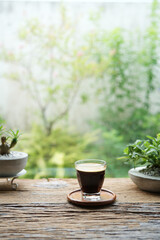 Coffee glass cup on rustic wood table by the window
