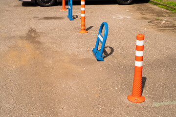 Blue metal parking barrier and orange cones in a car park